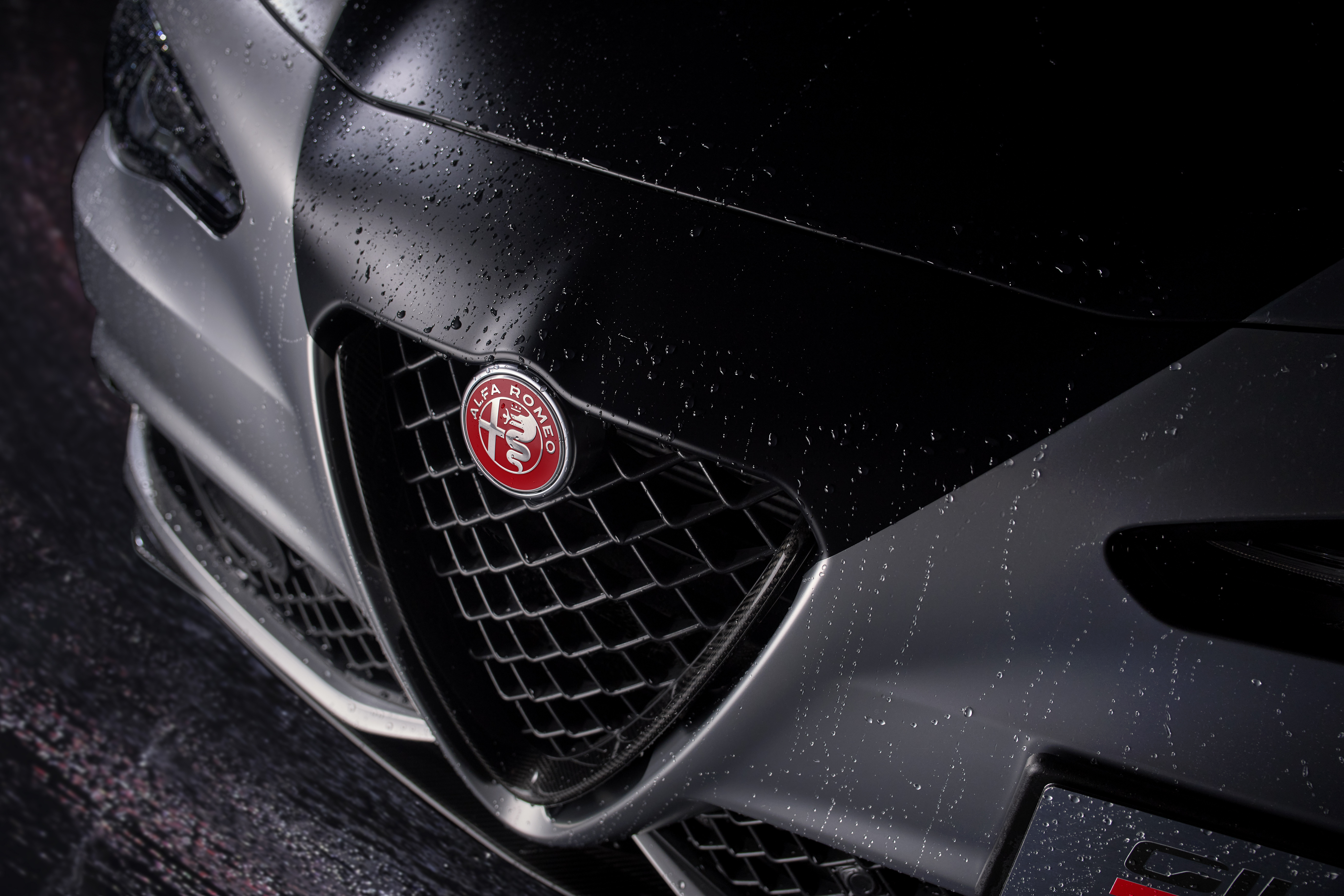 Emblema Alfa Romeo sobre fundo vermelho no Giulia Quadrifoglio Luna Rossa