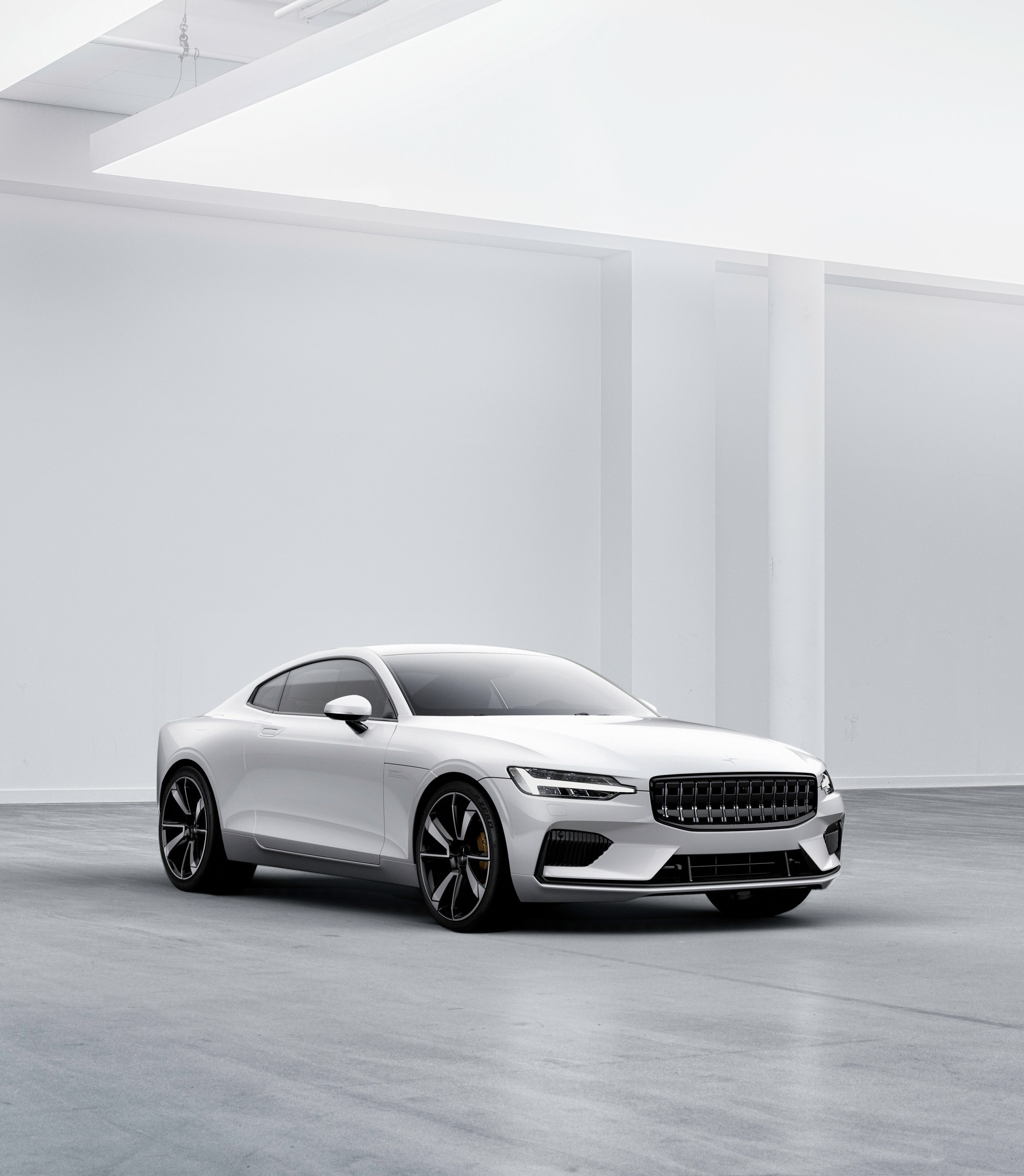 Polestar 1 branco em estúdio, visto de três quartos dianteiros.