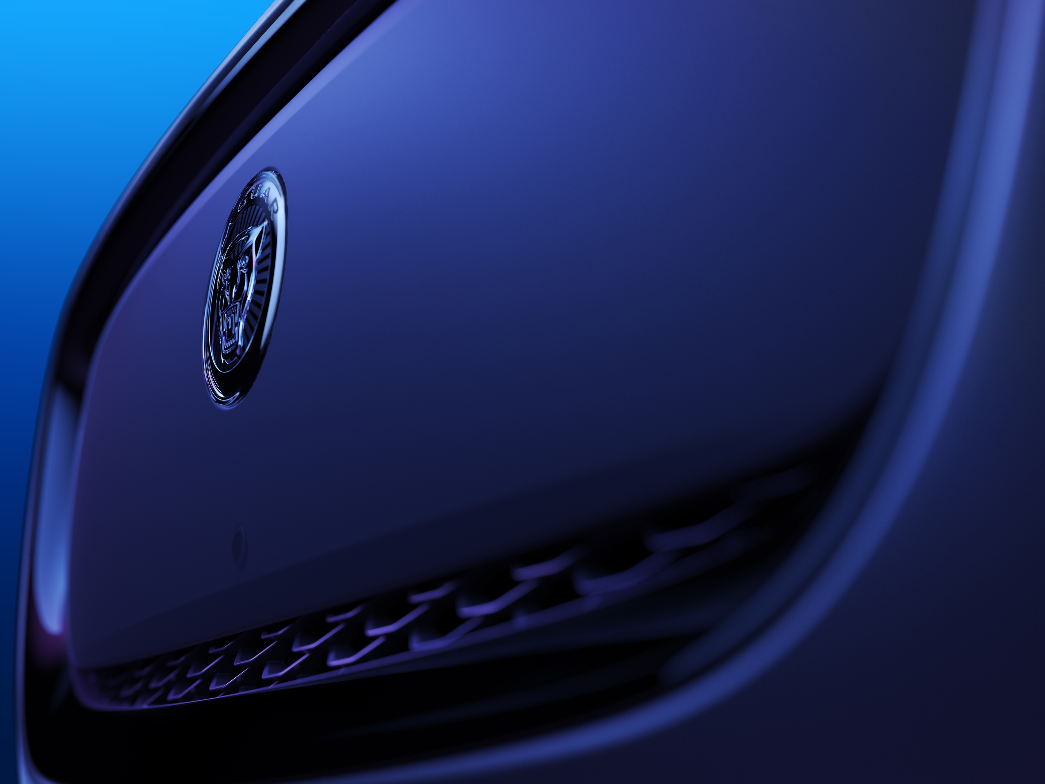 Detalhe da dianteira do I-PACE MY24, revisto em janeiro de 2023: superfície mais fechada e tratamento do emblema.