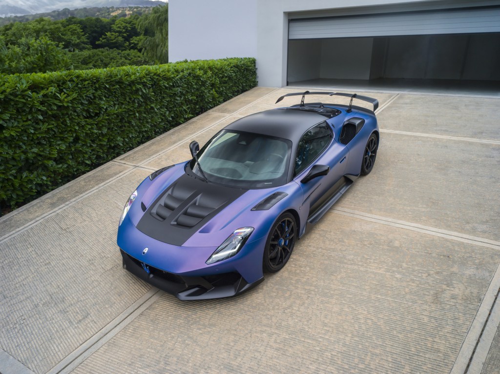 Maserati GT2 Stradale azul em vista elevada de três quartos dianteiros, junto a uma garagem.